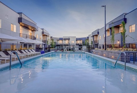 A large indoor swimming pool with lounge chairs and umbrellas.