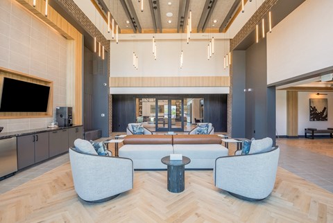 a living room with a couch and chairs and a tv