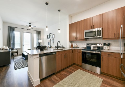 a large kitchen with stainless steel appliances and wooden cabinets