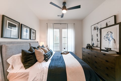 a bedroom with a large bed and a ceiling fan