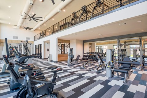 a gym with cardio machines and weights on a checkered floor