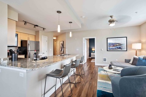 an open living room and kitchen with a marble counter top