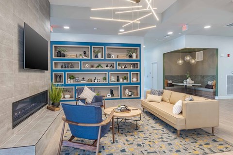 A modern living room with a blue chair and a fireplace.