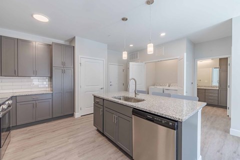 A modern kitchen with a stainless steel dishwasher and a granite countertop.