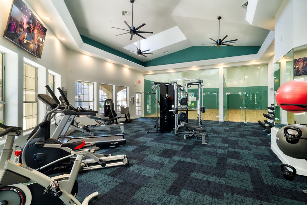a gym with treadmills and other exercise equipment in a building with green walls