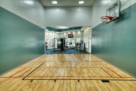 the court in the gym with a basketball hoop and a scoreboard