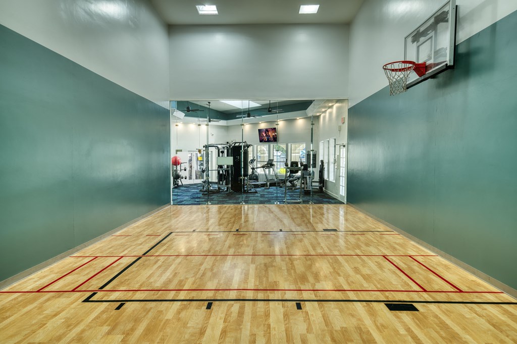 the court in the gym with a basketball hoop and a scoreboard