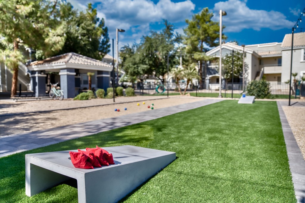 a red bouquet sits on a bench on the grass in front of a park