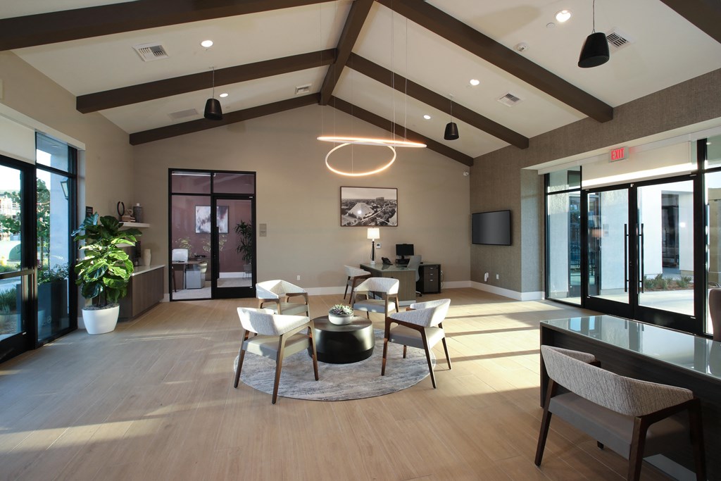 a large living room with a table and chairs and sliding glass doors