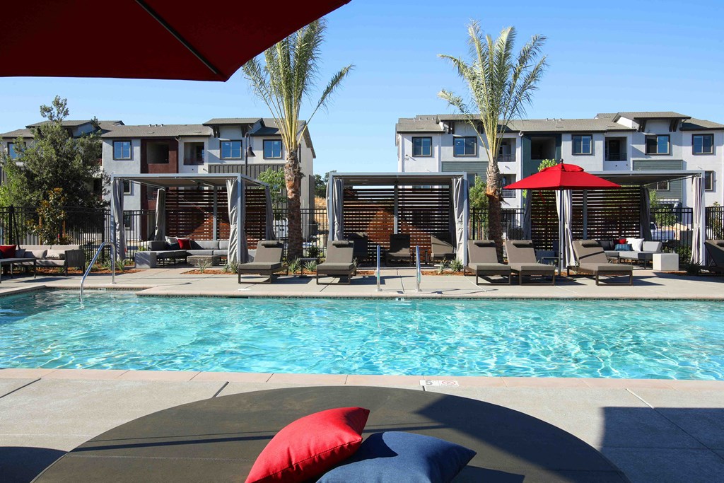 apartments with a swimming pool and red umbrellas