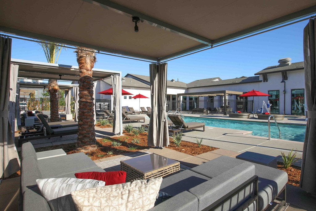 a patio with couches and chairs next to a pool