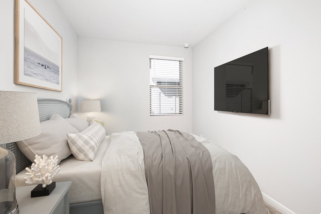 a bedroom with a bed and a tv on the wall