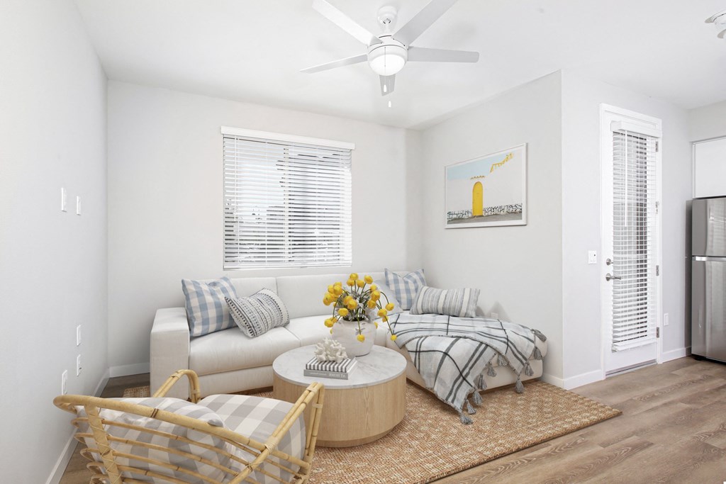 a living room with a couch and a table and a ceiling fan