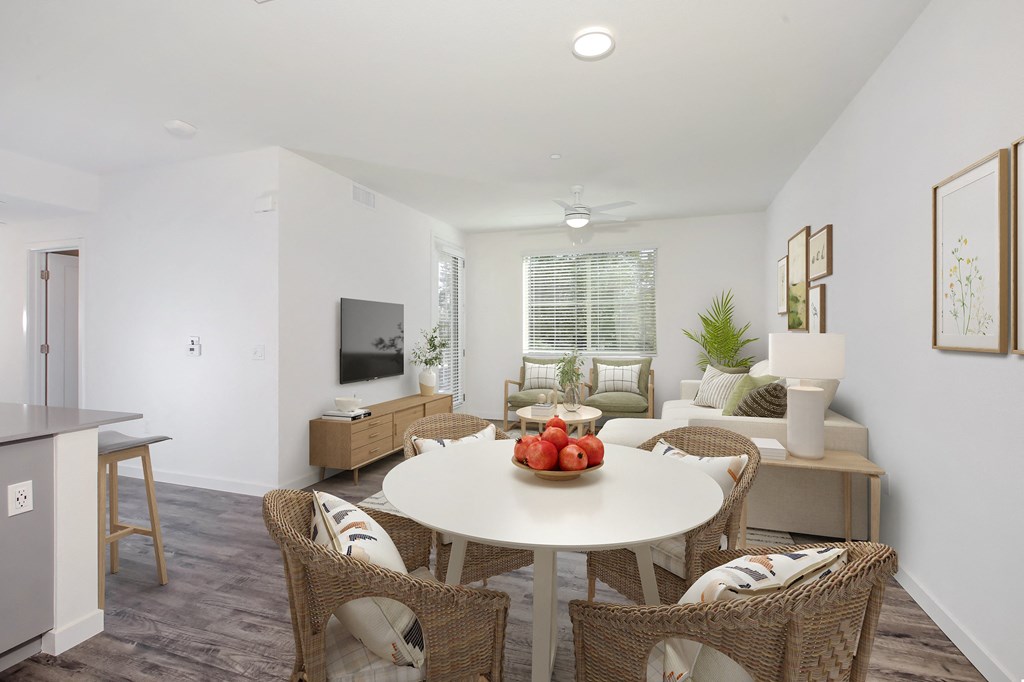 a living room and dining room with a table and chairs