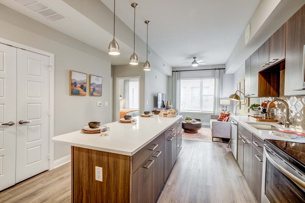 Kitchen view of island, appliances and living room