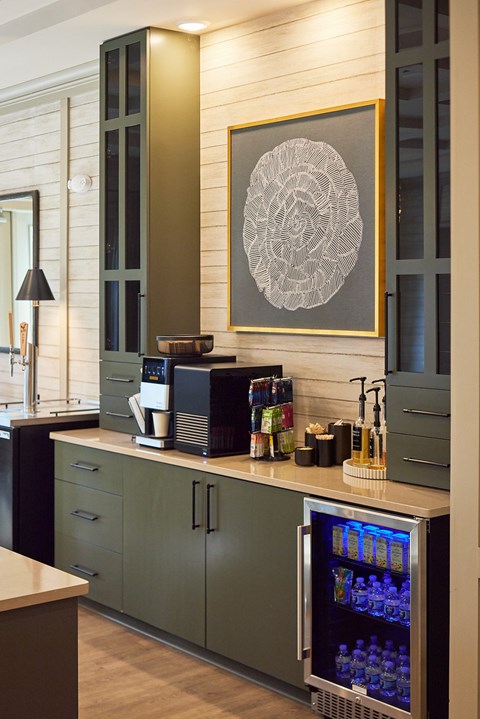 A modern kitchen with a green cabinet and a fridge with a glass door.
