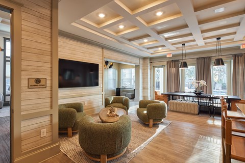 A living room with a large flat screen TV mounted on the wall.