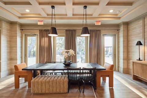 A dining room with a black table and chairs.