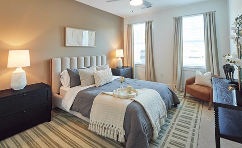 A bedroom with a large bed and a striped carpet.