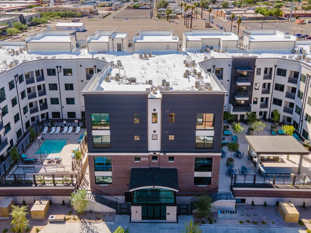 an aerial view of a building with a pool and apartments