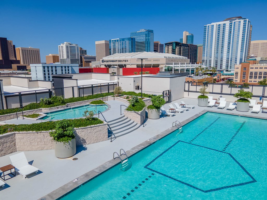 a pool on the roof of a building with a city in the background