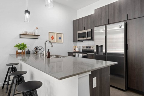 a kitchen with a marble counter top and a stainless steel refrigerator