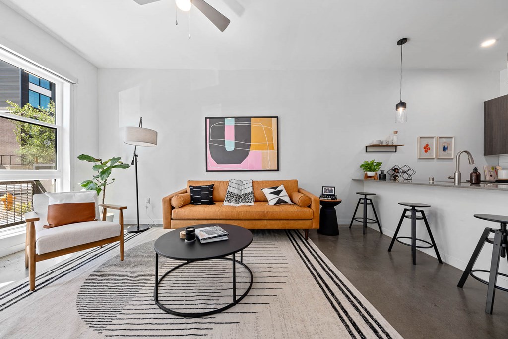 a living room with a couch and a bar and a window