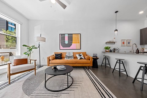 a living room with a couch and a bar and a window