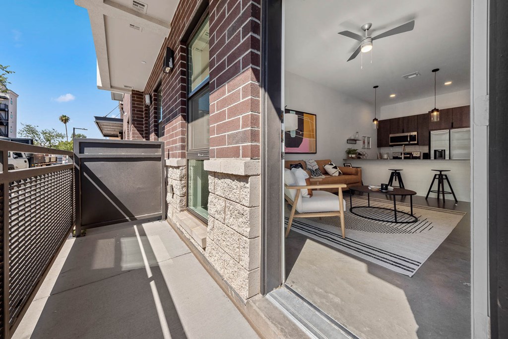 a balcony with a table and chairs and a living room