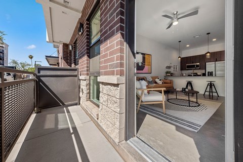 a balcony with a table and chairs and a living room