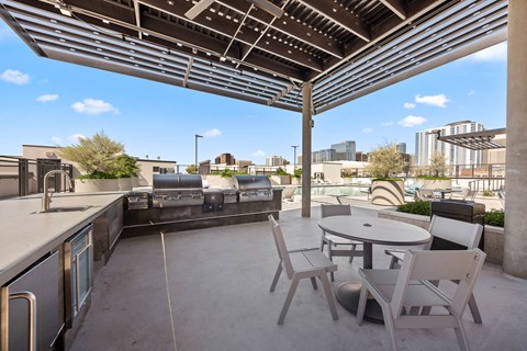 a patio with a table and chairs and a city in the background