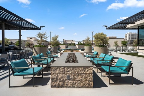 a patio with blue chairs and tables and a fountain