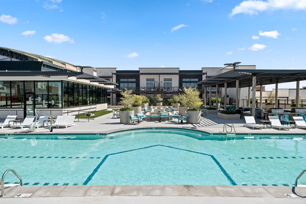 a swimming pool with lounge chairs and umbrellas