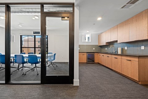 a conference room with a table and chairs and a kitchen