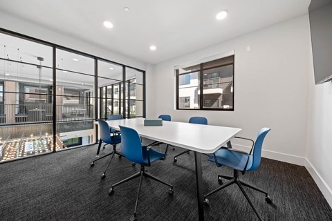 a conference room with a white table and blue chairs