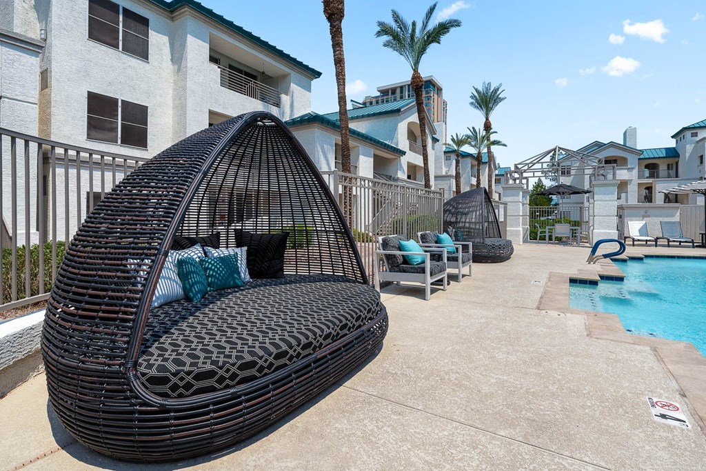 a swing chair next to a swimming pool