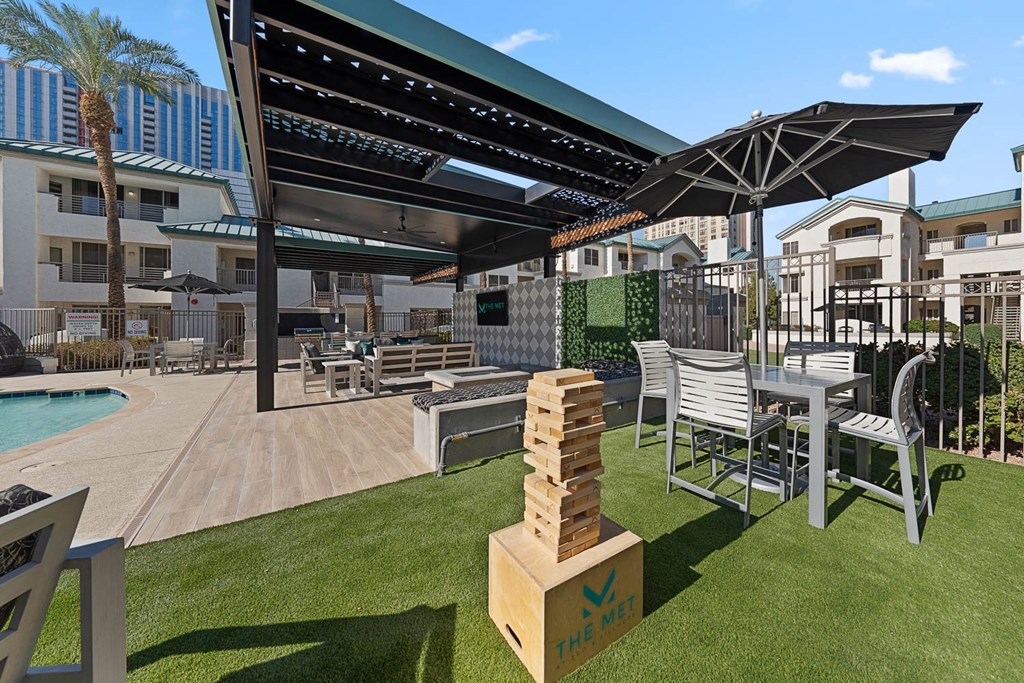 A patio area with a pool and a table and chairs.
