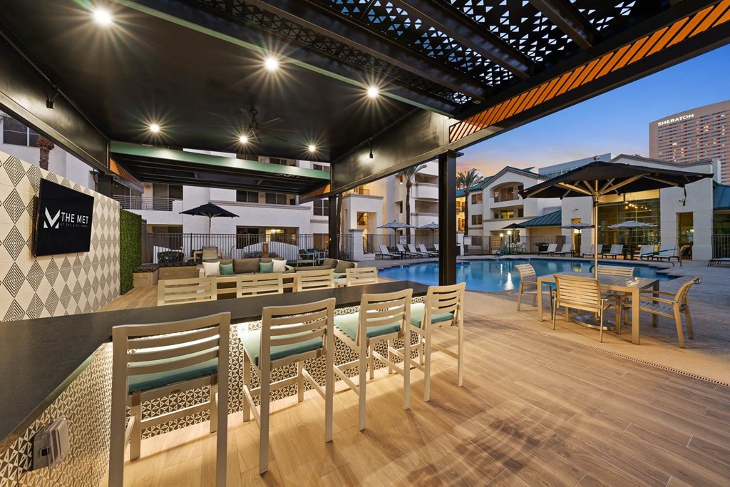 A poolside area with wooden chairs and tables.