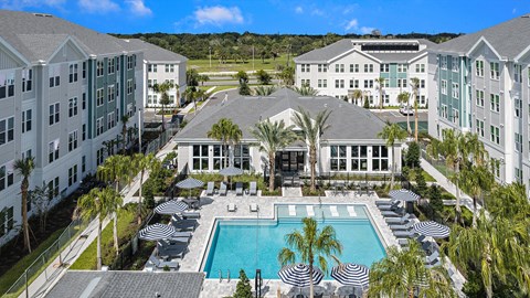 A large resort with a pool and palm trees.