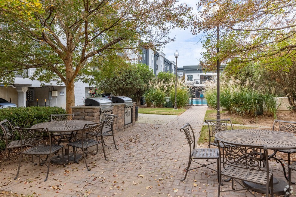 an outdoor patio with tables and chairs and trees