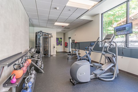 a gym with exercise equipment and a large window