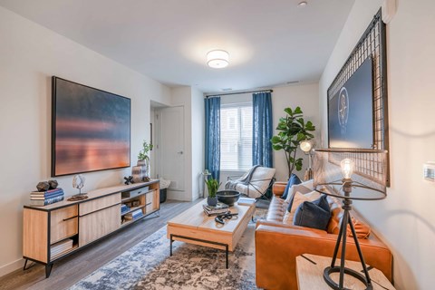 a living room with a couch coffee table and a tv on the wall