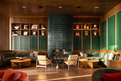 A living room with a green sofa and a wooden table.