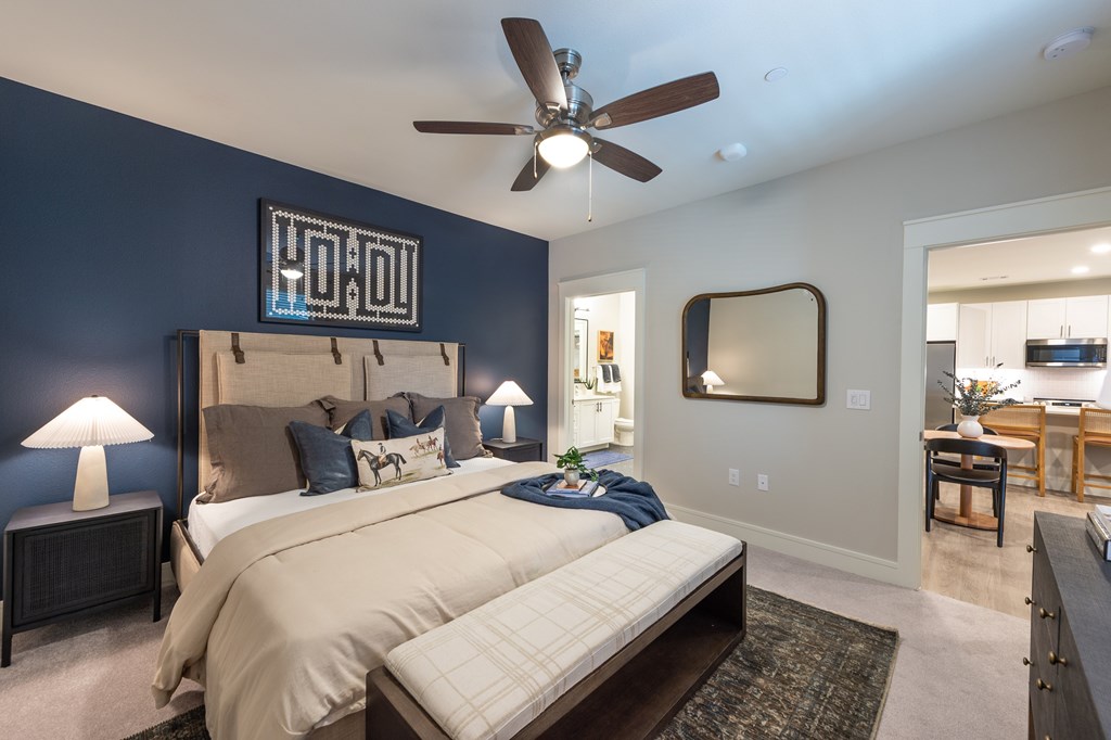 A bedroom with a large bed and a ceiling fan.