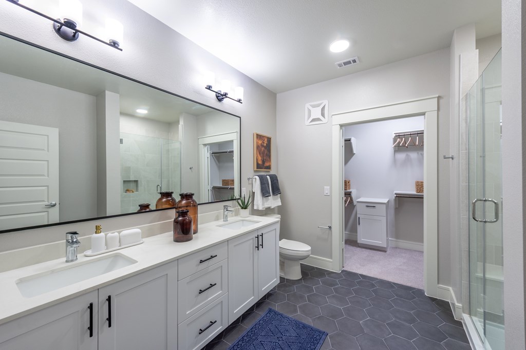 A bathroom with a sink, mirror, and toilet.