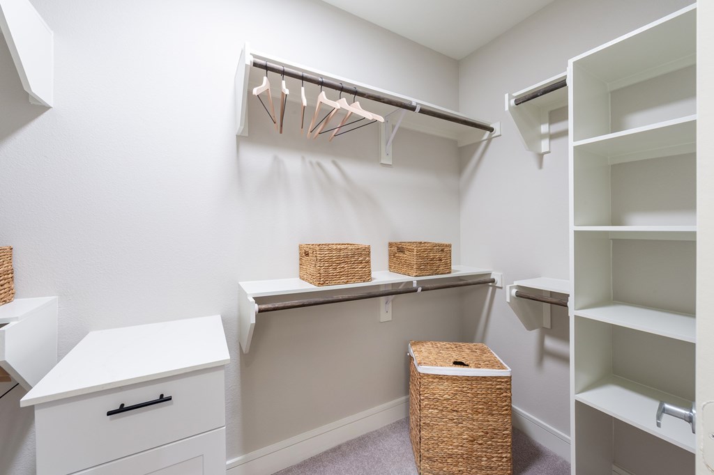 A white closet with a shelf and a basket.
