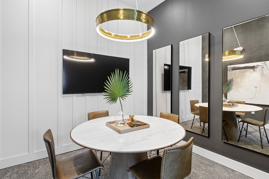 A modern dining room with a round table and chairs.