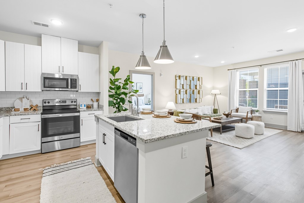 A modern kitchen with white cabinets and stainless steel appliances.