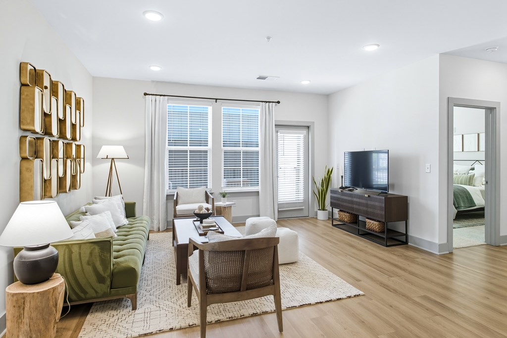 A living room with a green couch, a wooden table, and a television.