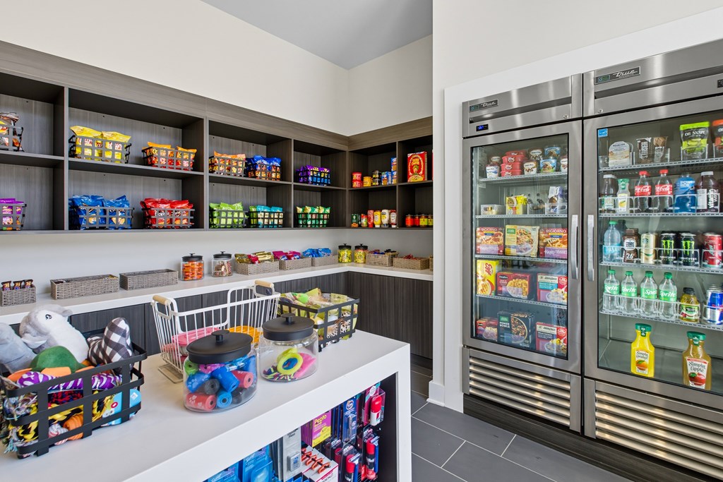 A refrigerator and freezer are on the right, and a shelf with many items is on the left.